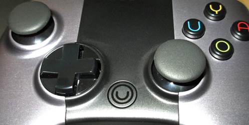 A fifth button positioned between the d-pad and right analog stick, which is marked with the logo OUYA (a circle with a U inside)