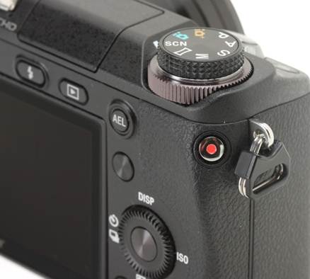 Description: The movie record button is placed concavely, slightly awkwardly, along the right edge of the camera at a 45 degree angle. While requiring a two handed hold of the camera, its location prevents inadvertent activation, which turns into a serious issue on the NEX-7.