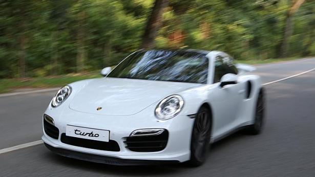 Boasting more firepower, the new Porsche 911 Turbo sports a retractable rear spoiler that looks broader and higher than before, and huge air intakes that up its aggressiveness quotient. -- ST PHOTO: ONG WEE JIN